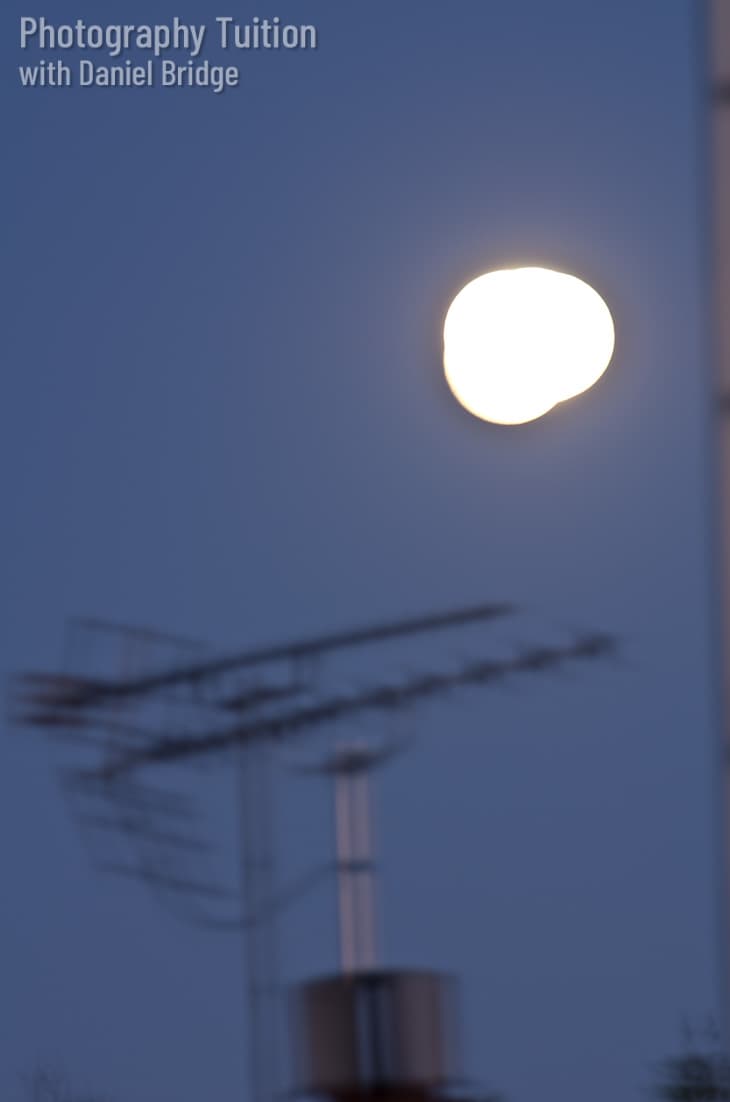 Poor shot of a full moon, too bright, and the moon is blurred.