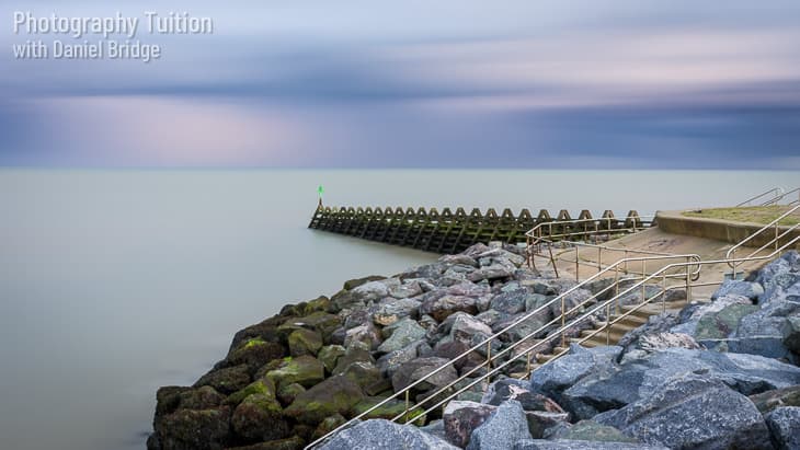 A long exposure shot of rocks and breakwater